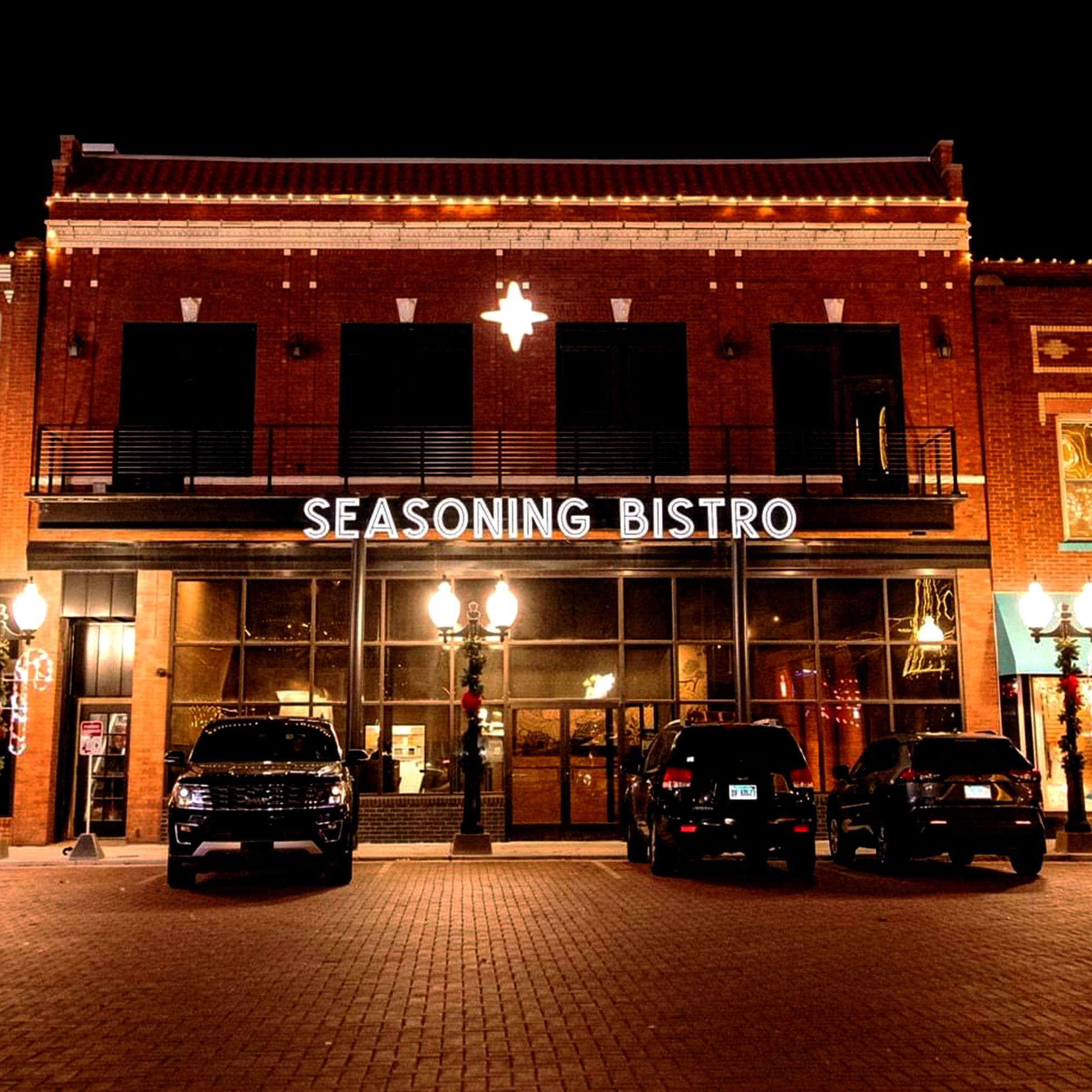 Exterior view of Seasoning Bistro on the Marion Square at night